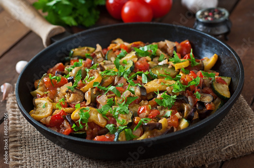 Vegetable Ratatouille in frying pan on a wooden table