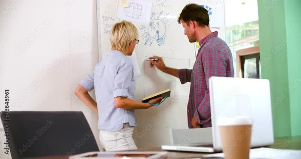 Two Businesspeople Having Brainstorming Meeting In Office Two Businesspeople Having Brainstorming Meeting In Office