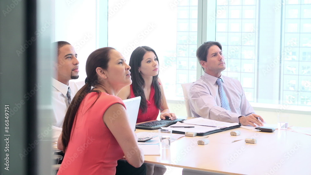 Four Businesspeople Having Video Conference In Boardroom 