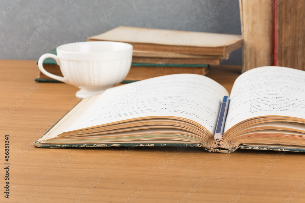 Naklejka premium old book with pencil and coffee