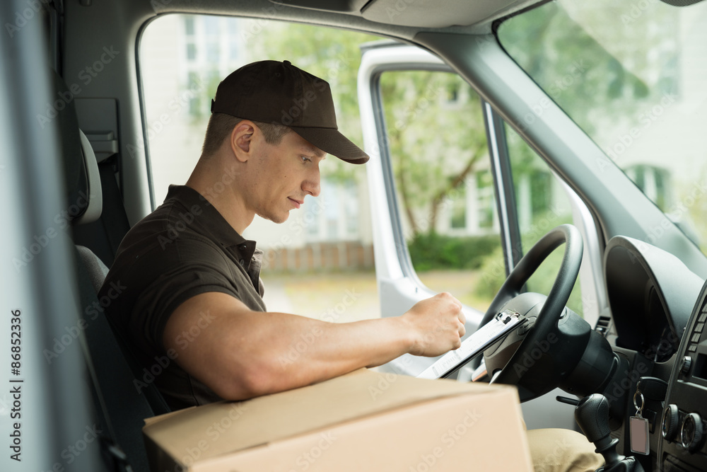 Delivery Man Checking List In Van