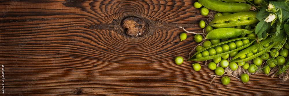 Fresh organic green peas on a wooden background. Rustic style.