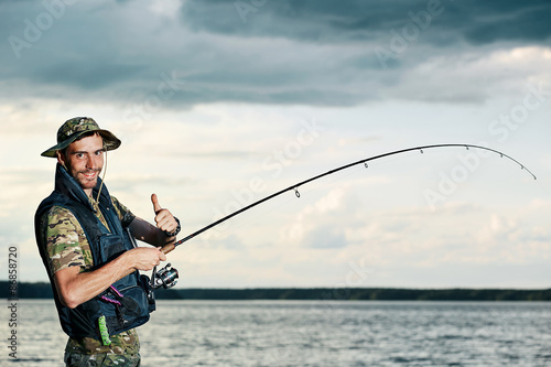 Man fishing on the lake during your vacation looks into the came