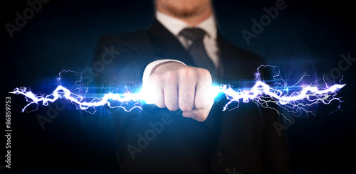 Business man holding electricity light bolt in his hands