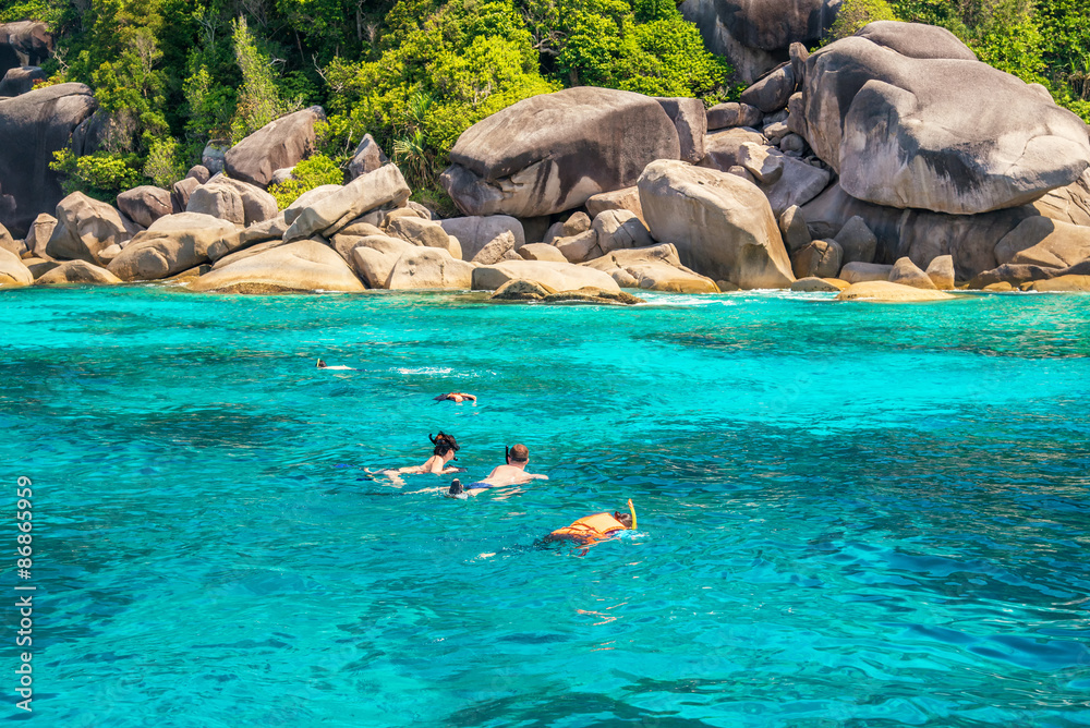 Fototapeta premium three traveller snorkeling in the tropical sea at sunny day