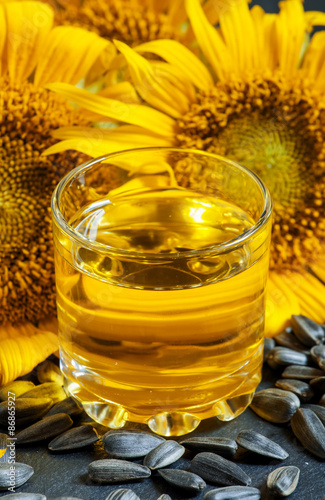 Fresh sunflower oil in a glass with flowers sunflowers and sunfl photo