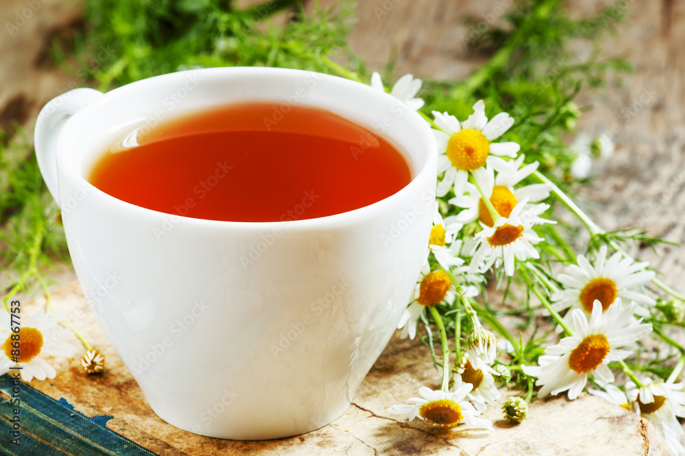 cup of black tea, wild chamomile, old books on wood background, cup of black tea, wild chamomile, old books on wood background,