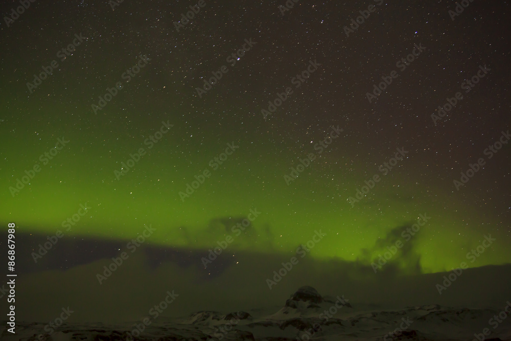 Northern lights with snowy mountains in the foreground