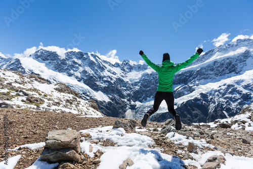 Woman Traveler with Backpack hiking in Mountains