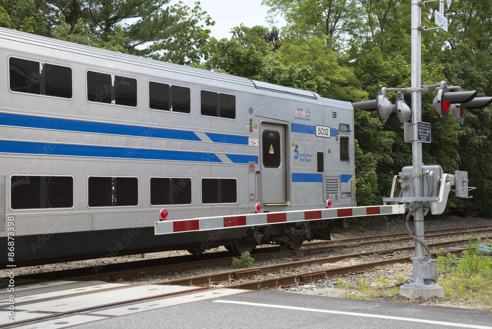 Fototapeta premium MTA Long Island Railroad train passing a level crossing at Mattituck USA