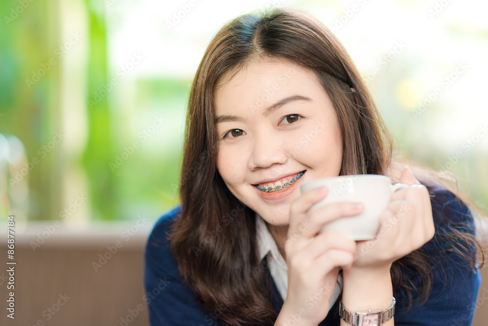 Young Business asian smiling woman Having a Coffee Break. Close Young Business asian smiling woman Having a Coffee Break. Close
