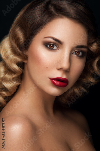 Amazing facial portrait of beauty girl with brown eyes  dark brown eye-shadows and deep red lipstick  with ambre effect and curls hair on dark background