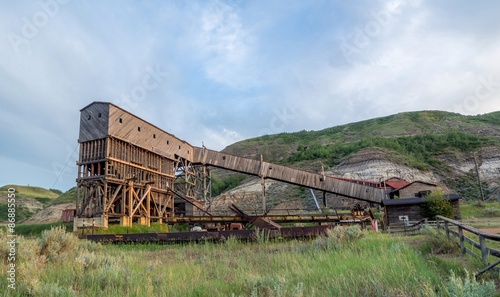 An old and historic coal mine building in the badlands region near Drumheller Alberta Canada at sunset.