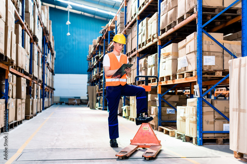 Fotografie Asian man in industrial warehouse checking list
