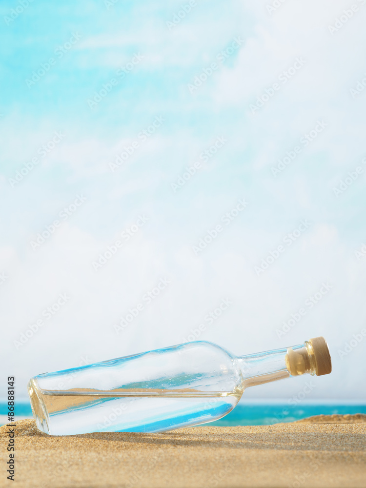 A bottle in the sand on the beach. A bottle in the sand on the beach.