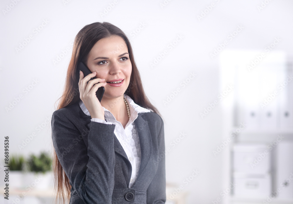 Smiling businesswoman talking on the phone at the office Smiling businesswoman talking on the phone at the office