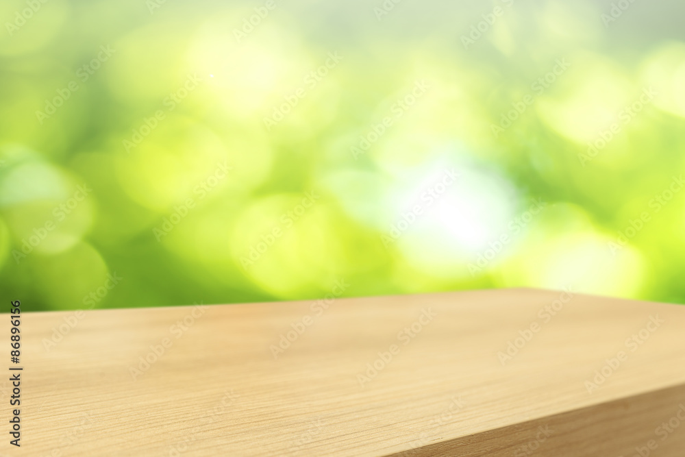 Empty wooden table and green natural spring blur bokeh backgroun