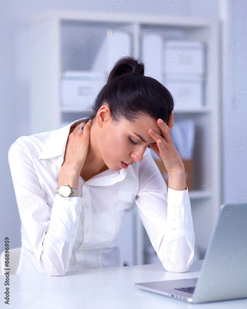 Stressed businesswoman sitting at desk in the office Stressed businesswoman sitting at desk in the office