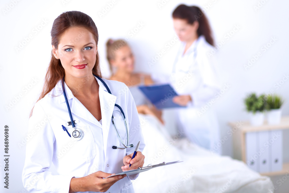 Smiling female doctor with a folder in uniform standing at Smiling female doctor with a folder in uniform standing at