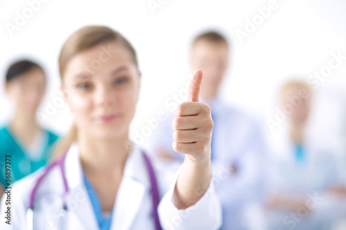 Young happy female doctor showing thumbs up