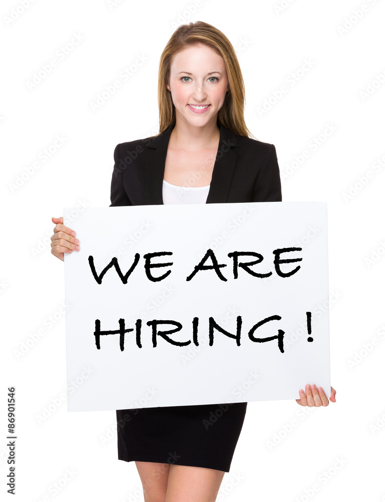 Businesswoman show a white poster with phrase of we are hiring Businesswoman show a white poster with phrase of we are hiring