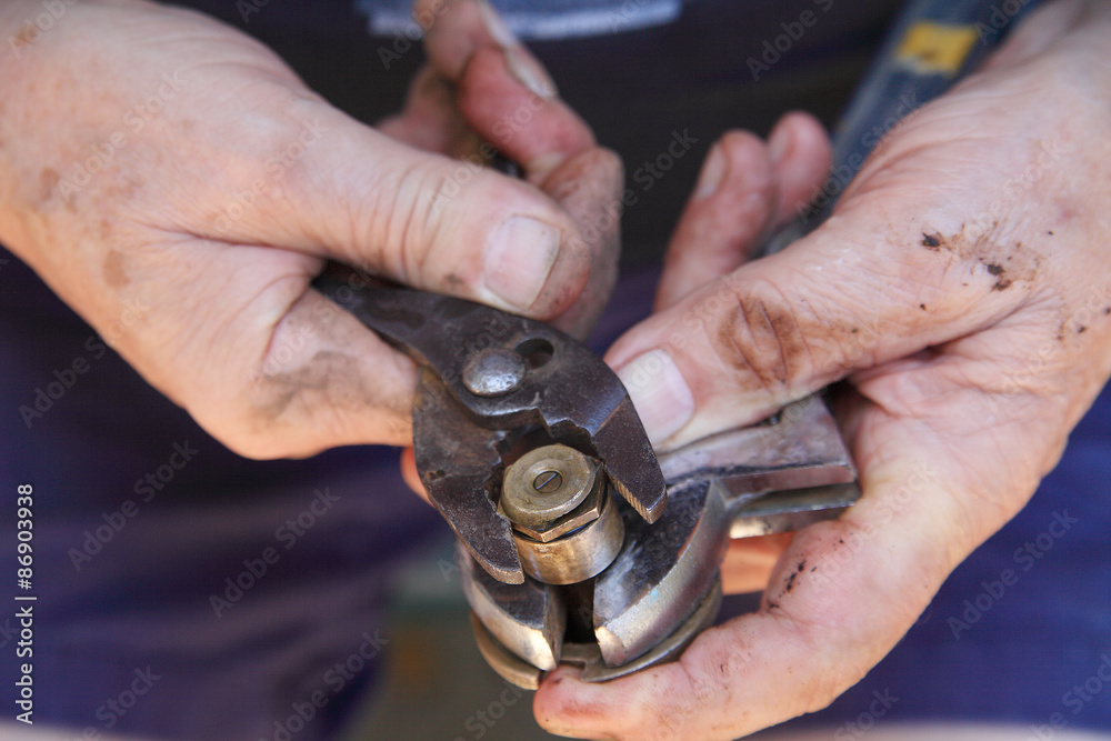 Man tightens sprinkler head with pliers