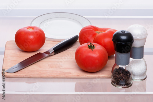 Tomatoes and knife on a chopping board
