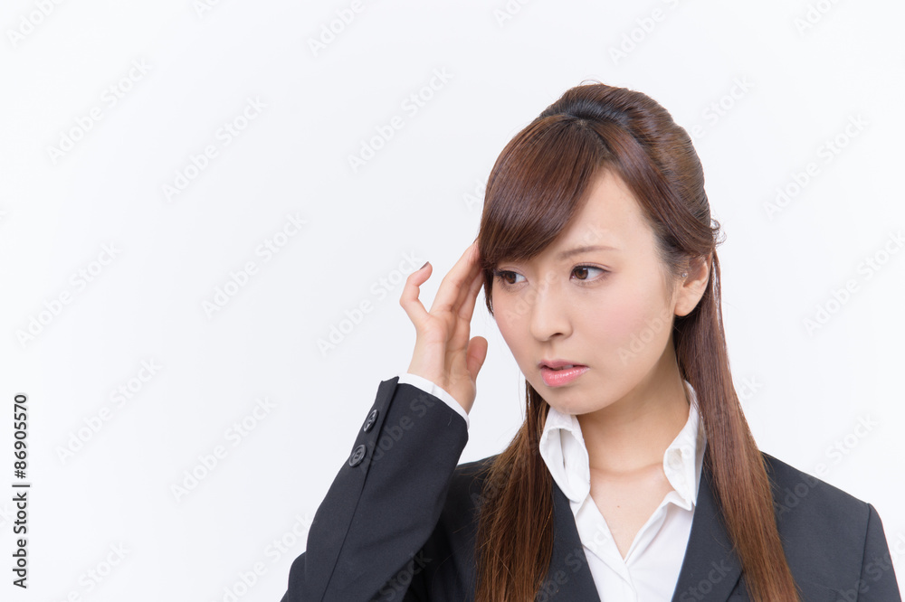 頭を抱え悩める若いスーツ姿の日本人女性 頭を抱え悩める若いスーツ姿の日本人女性