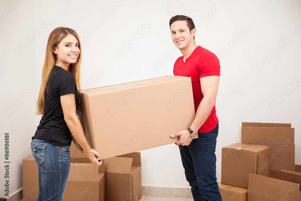 Cute couple carrying a big box Cute couple carrying a big box