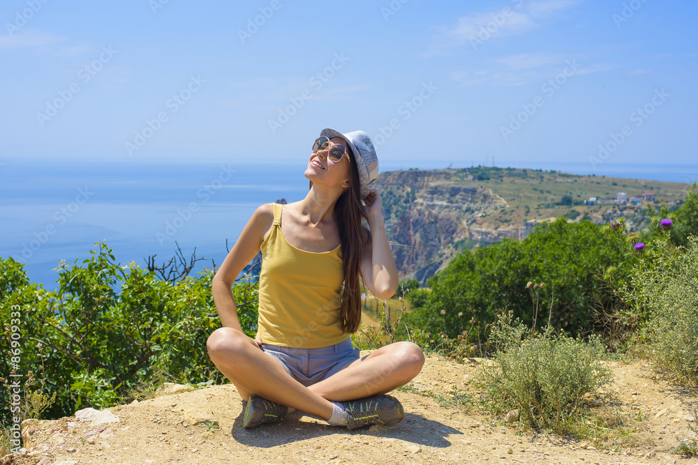 young beautiful caucasian female on a cliff above the sea young beautiful caucasian female on a cliff above the sea