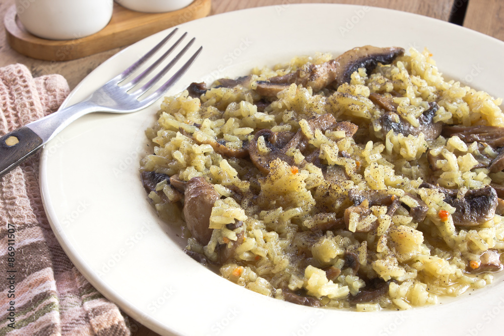 Risotto with mushrooms on plate with fork Risotto with mushrooms on plate with fork