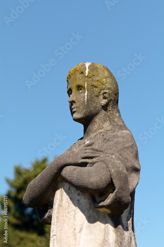 Grave stone statue of man covered in bird poo in Bordeaux, France