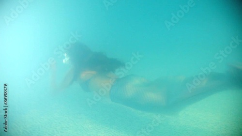 Beautiful woman in  diving in and swimming underwater.