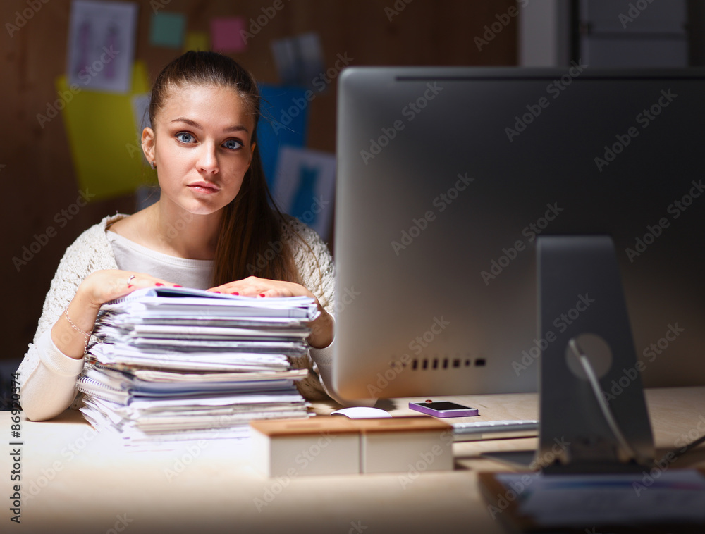 Young woman working in office, sitting at desk Young woman working in office, sitting at desk