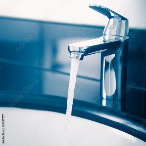 faucet with flowing water  blue tone