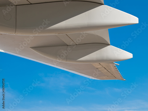 White jumbo wing flap details isolated on blue sky
