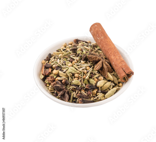Mix herbs and spices in white bowl over white background