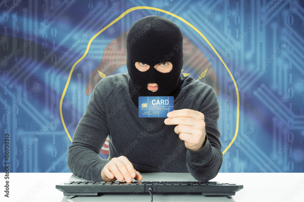 Hacker holding credit card and USA state flag on background - Utah Hacker holding credit card and USA state flag on background - Utah