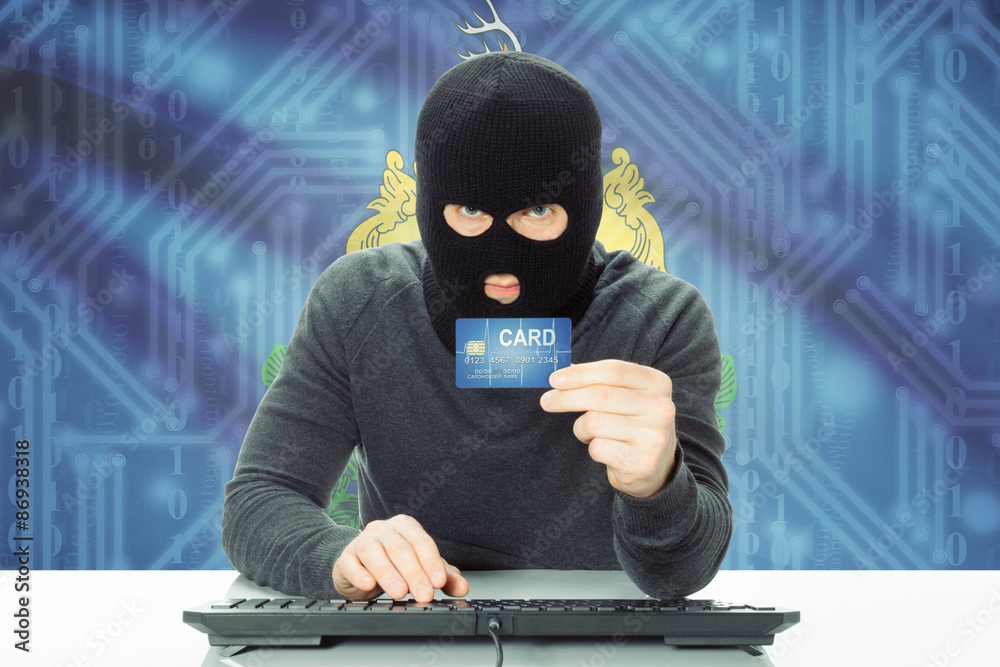 Hacker holding credit card and USA state flag on background - Vermont Hacker holding credit card and USA state flag on background - Vermont