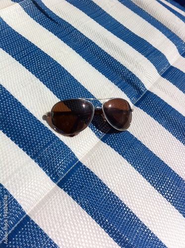 Men's sunglasses lying on beach litter