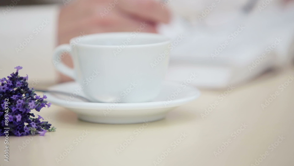 Mans hand with a close up of a cup and a bouquet of lavender. Mans hand with a close up of a cup and a bouquet of lavender.
