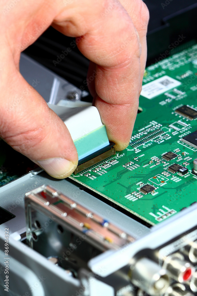 Circuit board.
Man connecting cable to a circuit board. Circuit board.
Man connecting cable to a circuit board.
