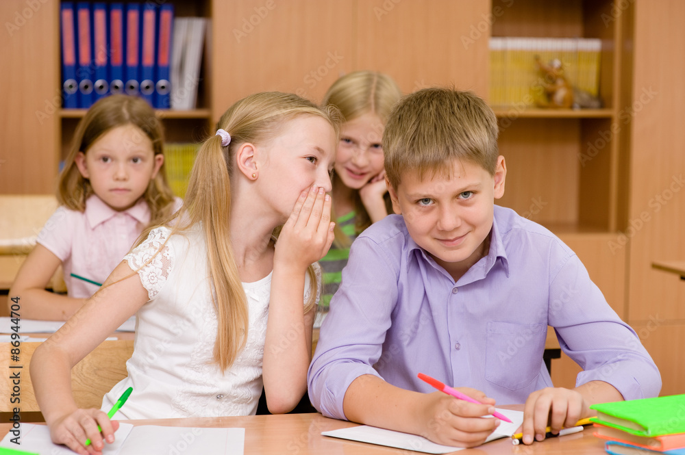 girl whispering secrets of the boy in the classroom girl whispering secrets of the boy in the classroom
