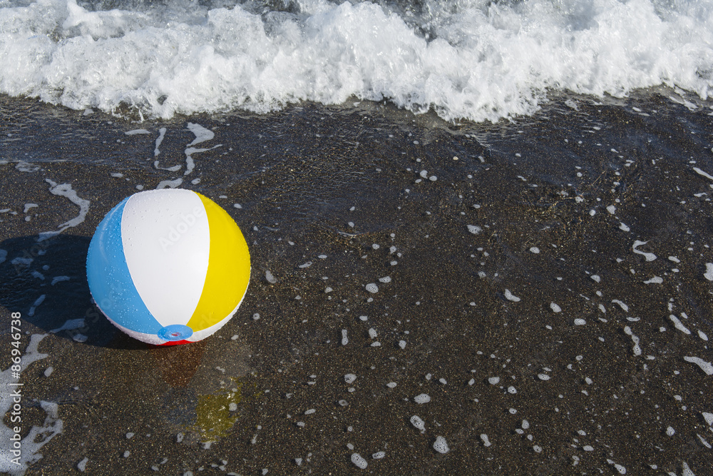 Colorful ball on the seashore. Focus on ball