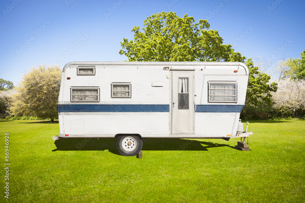 Classic Old Camper Trailer In Grass Field Classic Old Camper Trailer In Grass Field