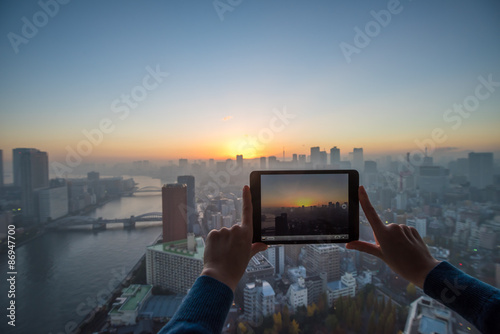 Girl taking picture of Tokyo with tablet