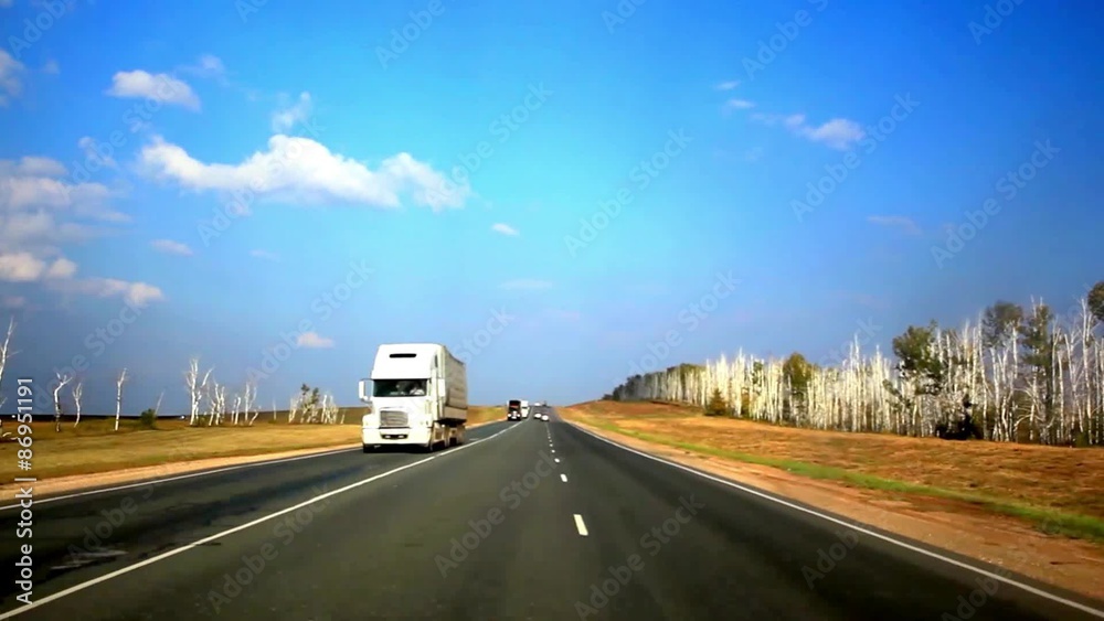 Cars drives on the asphalt road and sky background with clouds Cars drives on the asphalt road and sky background with clouds
