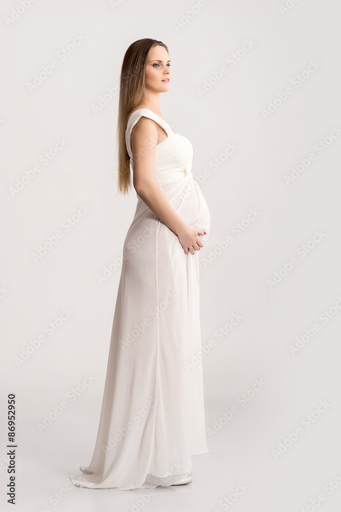 Young and beautiful pregnant woman in antique dress over grey background with a lot of blank space Young and beautiful pregnant woman in antique dress over grey background with a lot of blank space