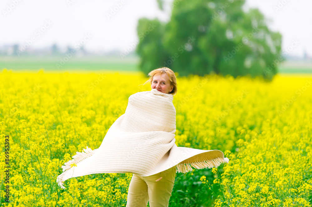 The beautiful woman dances on a rape field The beautiful woman dances on a rape field