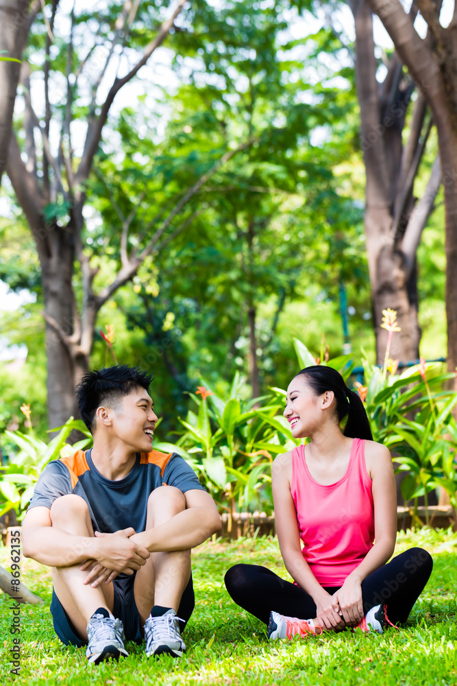 Asian couple having break at during sport training Asian couple having break at during sport training